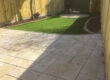 Two patio areas, lawn, flower beds and fencing
