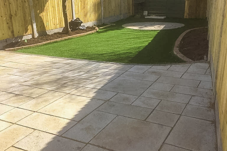 Two patio areas, lawn, flower beds and fencing